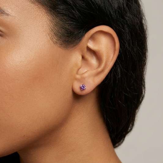 Clous d'oreilles en argent 925, avec une améthyste violette, portés à l'oreille.